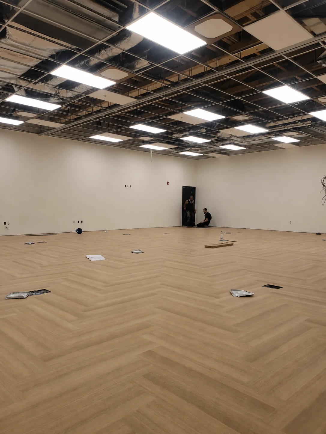 Geometrix Flooring & Design installation team on a commercial herringbone wood-look LVT job