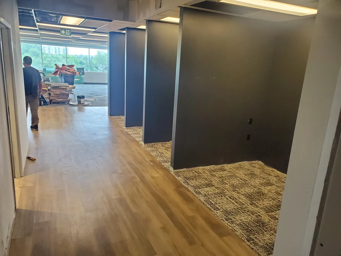 Corporate office renovation — wood-look LVT corridor with patterned modular carpet-tile inlays installed by Geometrix